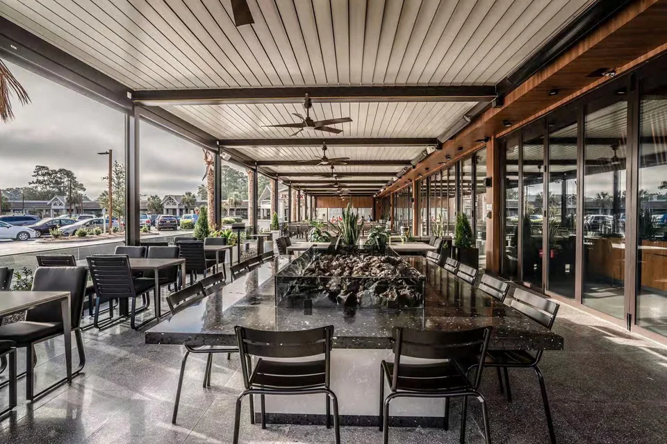 Bi-folding glazing alongside a covered restaurant terrace with tables and chairs