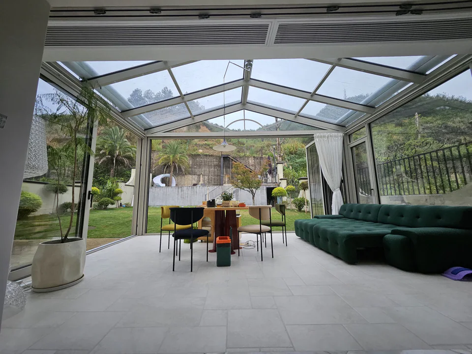 Bright glazed garden room with folding doors opened to the surrounding landscape