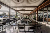 Bi-folding glazing alongside a covered restaurant terrace with tables and chairs