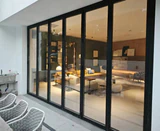 Closed full-height bi-folding doors separating a living room and a glazed terrace