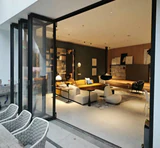 The same living space with bi-folding panels stacked to open the room to the terrace